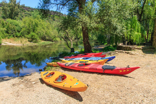 colorful kayaks on a river bank