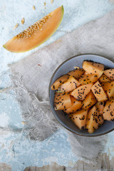 Fototapeta na wymiar snack with pieces and slice of melon and sesame seed on bowl