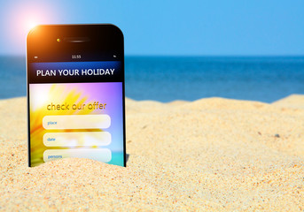 mobile phone with holiday planner on the beach