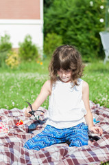 Cute happy little girl playing with toys in the garden on a summ