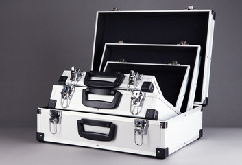 Opened silvery suitcases on grey background