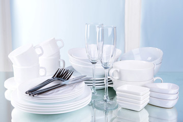 Set of white dishes on table on light background