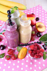 Bottles of delicious smoothie on table, close-up