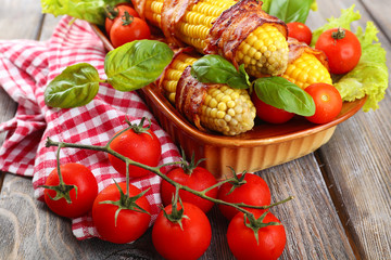 Grilled bacon wrapped corn on table, close-up