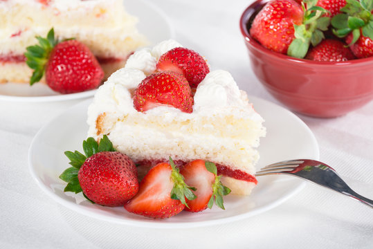 Slice of homemade strawberry cream cake with strawberries