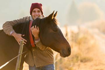 man hugging his horse