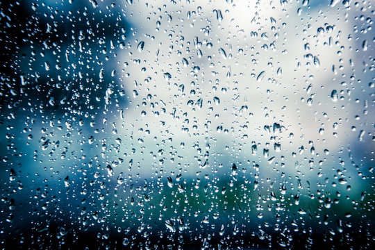 Many raindrops on blue light window glass