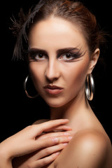 Fototapeta premium Woman with feather in head on black background