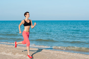 Young beautiful girl athlete playing sports on the beach