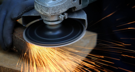 Worker cutting metal with grinder
