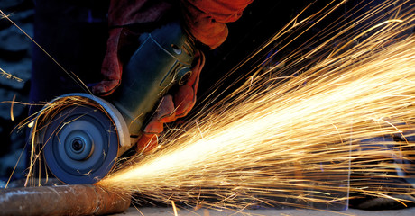 Worker cutting metal with grinder