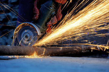 Worker cutting metal with grinder