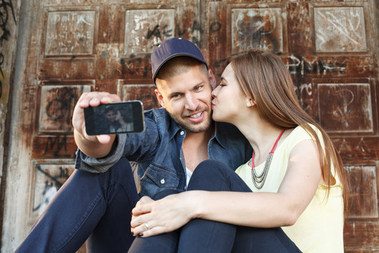 Young couple in embrace takes selfie