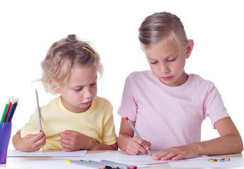 Cute blonde girls drawing with colored pencils