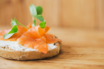Salmon tartine on rustic wooden background with shallow dof