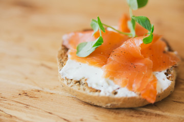 Salmon tartine on rustic wooden background with shallow dof