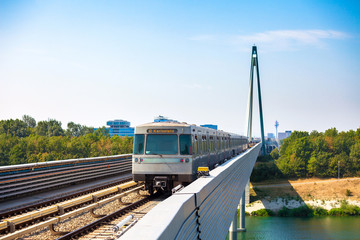 Vienna metro train passing a bridge over Danube river