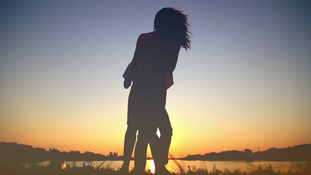 Young couple in love at sunset on the lake, enjoying each other,