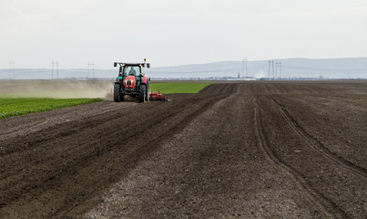 Farmer in tractor preparing land for sowing