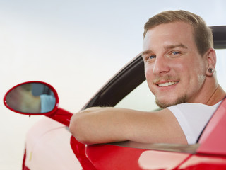 Man driving a red roadster