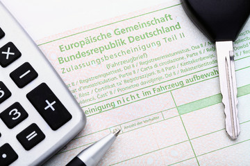 Symbolbild Fahrzeugbrief, Autoschlüssel & Rechner
