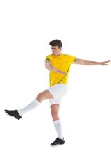 Fototapeta na wymiar Football player in yellow jersey kicking