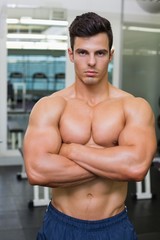 Fototapeta na wymiar Serious young muscular man in gym