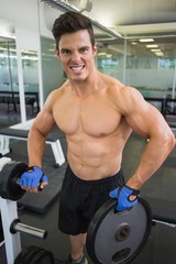 Fototapeta na wymiar Shirtless young muscular man lifting weight in gym