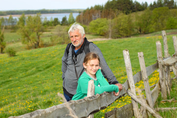 Grandfather with his granddaughter travel at attractive places. 