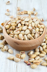 full bowl of pistachio on wooden surface