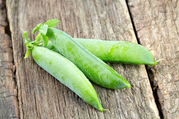 fresh pea pods on wooden surface