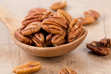 pecan nuts in a wooden spoon