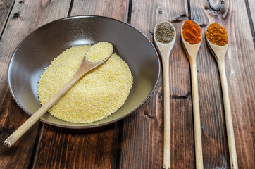 Spice on spoon with bowl of couscous