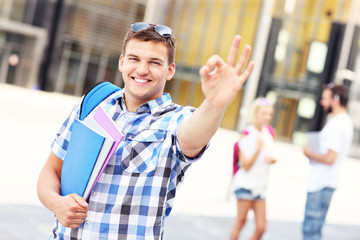 Handsome student showing ok sign in the campus