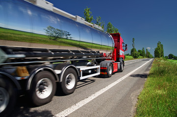 Obraz na płótnie Canvas Mirroring the landscape chrome tank truck moving on a highway