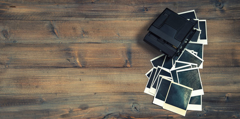 old photo frames and camera on rustic wooden background