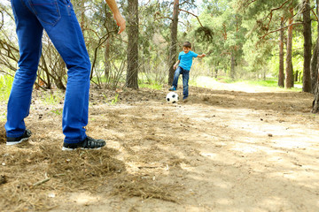 Fototapeta premium Happy dad and son playing football in the park