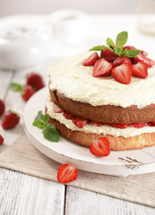 Delicious biscuit cake with strawberries on table close-up