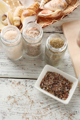 Different sea salt on wooden table, close up
