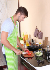 Handsome man cooking in kitchen at home