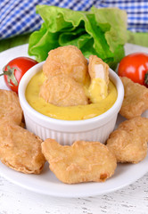 Chicken nuggets with sauce on table close-up
