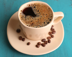 Cup of coffee on color wooden background