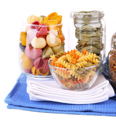 Colorful pasta in glass jars isolated on white