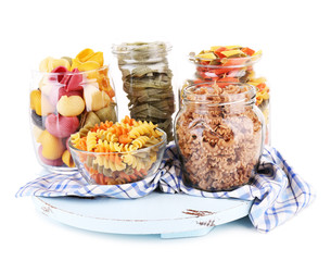 Colorful pasta in glass jars isolated on white