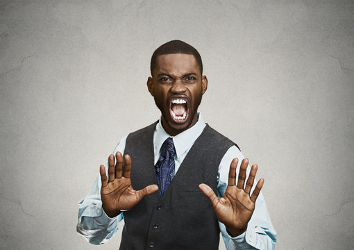 Angry executive gesturing with hands to stop, grey background 