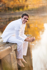 young man drinking red wine at sunset