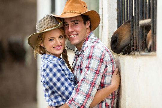 western couple hugging in stables