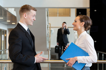 Co-workers laughing in business centre hall