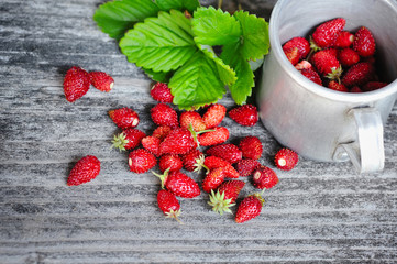 Fresh wild strawberries on an old wooden table