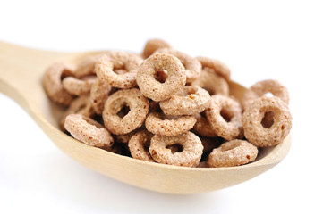Wooden spoon with cereal rings on white background